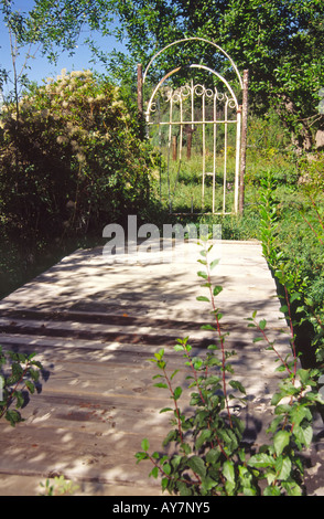 Un sentier mystérieux sur un pont en bois mène à un seul secret garden gate, près de San Ignacio, Nouveau Mexique. Banque D'Images