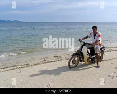 Man on motorcycle Hat Farang beach l'île de Ko Muk Thaïlande Banque D'Images