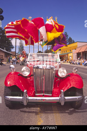 Les drapeaux flottent dans la brise comme moteur du Shriners le long dans une voiture sport rouge, à l'Aspenfest Parade à Albuquerque, Nouveau Mexique. Banque D'Images