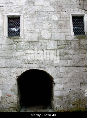 Entrée voûtée, bas avec porte en bois, avec deux hautes fenêtres. Les murs de bloc Banque D'Images