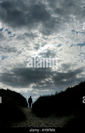 Figure la marche dans les dunes de sable contre moody sky UK Norfolk Banque D'Images