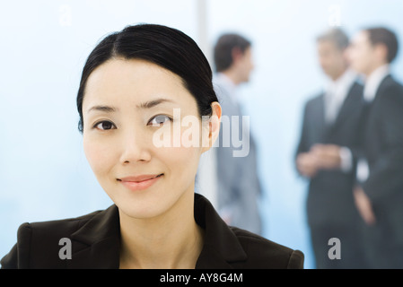 Businesswoman, portrait, collègues debout en arrière-plan Banque D'Images