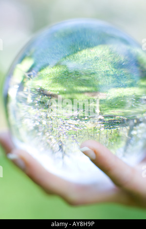 Woman holding glass ball dans la main à l'extérieur, extreme close-up Banque D'Images