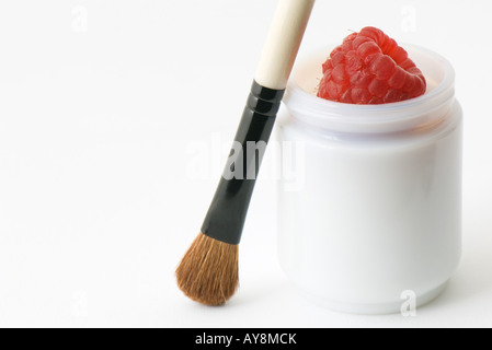Cosmétiques naturels, framboise fraîche en petit contenant, à l'aide de make-up brush Banque D'Images