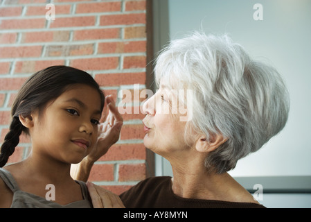 Grand-mère de toucher la tête de petite-fille, close-up Banque D'Images