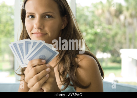 Teenage girl holding up cartes, smiling, portrait Banque D'Images