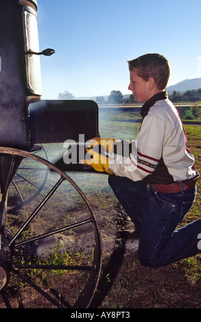 Un jeune chuck-wagon cuire attise les flammes d'un fumeur, à la Lincoln County Cowboy Symposium, dans la région de Ruidoso Downs, Nouveau Mexique. Banque D'Images