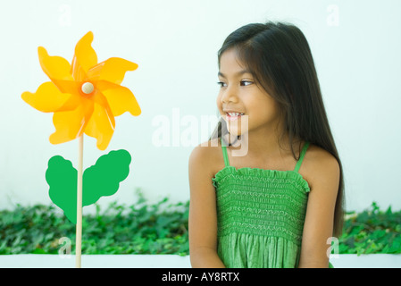 Petite fille à la fleur au moulinet en forme, smiling Banque D'Images