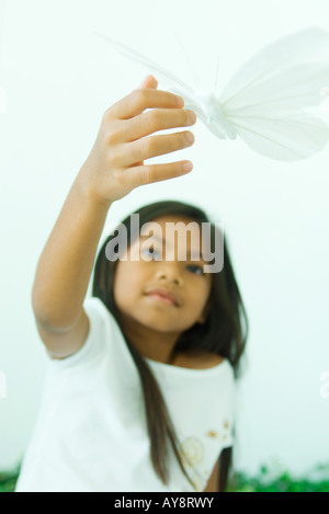 Petite fille toucher papillon, low angle view Banque D'Images