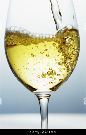 Le vin blanc est versé dans un verre de vin, close-up Banque D'Images