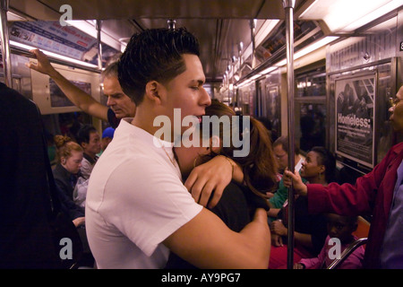 Un jeune couple hug au milieu de la foule aux heures de pointe du métro de Manhattan New York City Banque D'Images