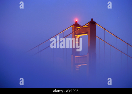 Tour du pont Golden Gate passant au-dessus du brouillard au coucher du soleil à San Francisco en Californie du Nord Banque D'Images