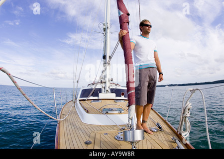 Homme debout sur le pont du yacht à voile, mode nautique, Cowes, île de Wight, Royaume-Uni Banque D'Images