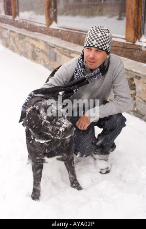 Man with dog in snowy street, Tignes, France Banque D'Images