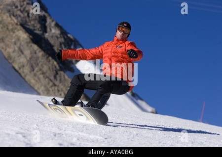 Planche à neige avec les bras en équilibre sur montagne, Tignes, France Banque D'Images