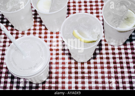 Verres en plastique remplis de limonade debout sur nappe vérifié Banque D'Images