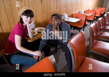 Inter-raciale Cheerful young couple sitting in a cafe Banque D'Images