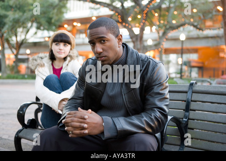 Les jeunes contemplative couple inter-raciale à un parc de la ville Banque D'Images