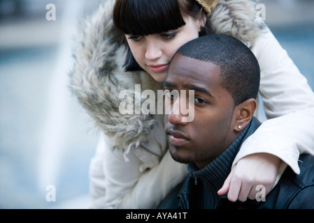 Close-up of a young contemplative couple inter-raciale sur un banc de parc Banque D'Images