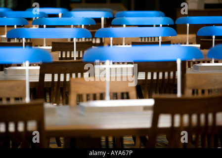 Vue sur des chaises et des tables vides et des rangées de lampes de table dans la salle de lecture d'une bibliothèque Banque D'Images