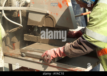 Close up de workman en utilisant un disque de coupe circulaire à haute vitesse à vu à travers des dalles pour les travaux de la rue Banque D'Images