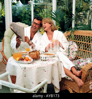 Couple studying leurs parts dans le journal Financial Times au moment du petit-déjeuner. Banque D'Images