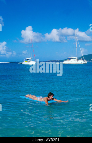 Fille bronzée sur lilo en mer dans les Caraïbes Banque D'Images