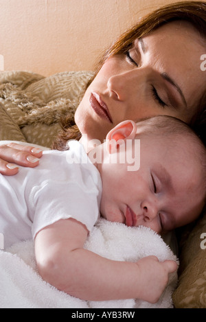 Close-up of a sleeping mère tenant un bébé à dormir sur ses épaules Banque D'Images