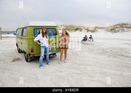 Portrait de jeunes femmes à la mode hippie par permanent van at beach Banque D'Images