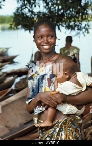 Portrait d'une femme souriante portant un bébé le long de la rivière Ngiri. République démocratique du Congo ex Zaïre Afrique Banque D'Images