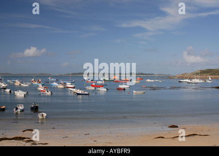 Bateaux amarrés à St Marys piscine avec vue sur la route vers les îles de St Martins et Tresco Banque D'Images