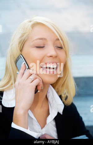 Young businesswoman sitting on stairway using cell phone Banque D'Images