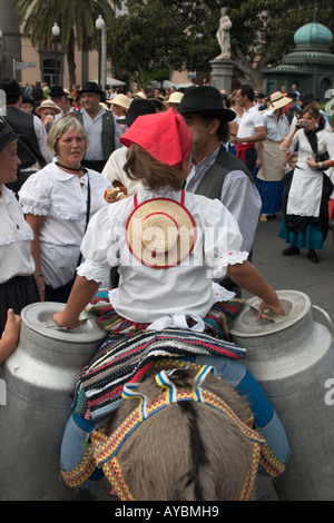 Jeune fille sur donkey transportant des bidons de lait à l'échelle locale la fiesta sur Gran Canaria dans les îles canaries Banque D'Images