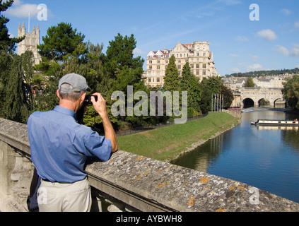 Un touriste photographies à partir d'un pont sur la rivière Avon à Bath Banque D'Images