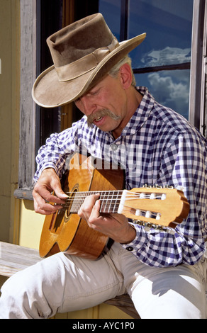 M. Wiley 0399 Peifer strum une guitare à la gare dans Chama, Nouveau Mexique. Banque D'Images