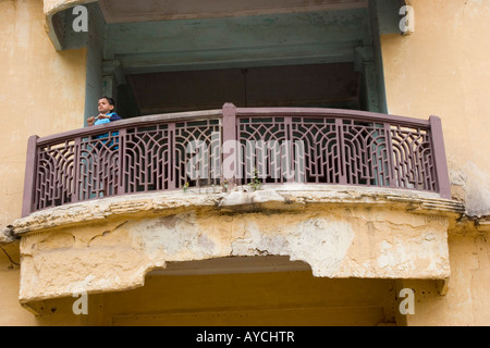 Petit garçon à la recherche sur le balcon d'une maison en Inde Banaglore Banque D'Images