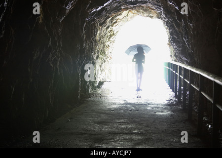 Woman Holding Umbrella dans Cave Banque D'Images