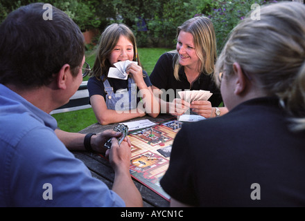 Une famille JOUER À UN JEU DANS LEUR JARDIN Banque D'Images