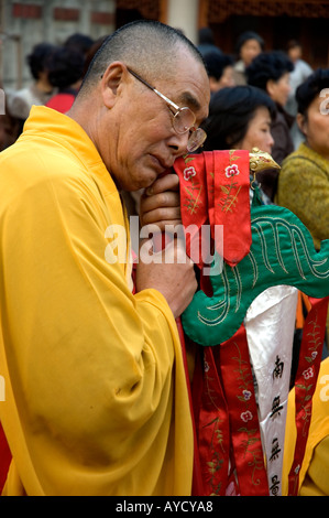 Un ancien moine bouddhiste se reposer pendant une procession religieuse à Jingan Temple, à Shanghai, en Chine. Banque D'Images