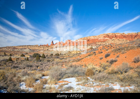 Les formations de nuages whispy sur des formations rocheuses avec neige de l'hiver au parc national Arches Banque D'Images