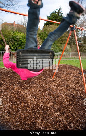 L'enfant sur une balançoire dans un parc de jeux pour enfants au Royaume-Uni Banque D'Images