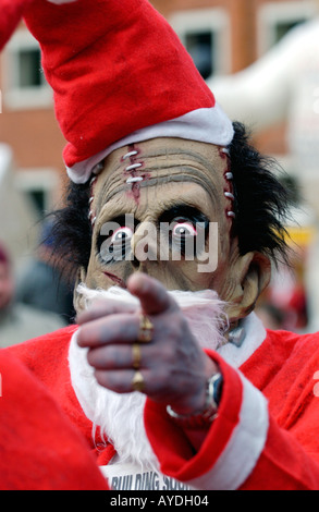 Personne pour l'utilisation d'un masque de monstre déguisé en Père Noël pour l'organisme de bienfaisance annuel Santa Fun Run à Newtown Powys Pays de Galles UK Banque D'Images