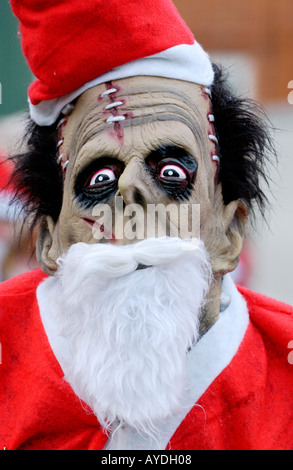 Personne pour l'utilisation d'un masque de monstre déguisé en Père Noël pour l'organisme de bienfaisance annuel Santa Fun Run à Newtown Powys Pays de Galles UK Banque D'Images