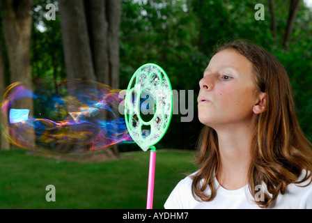 Young Girl blowing bubble géant à l'extérieur en cour arrière Banque D'Images