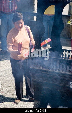 Femme avec des bougies en face d'encens à la Pagode de l'Oie Sauvage à Xi'an, Chine Banque D'Images