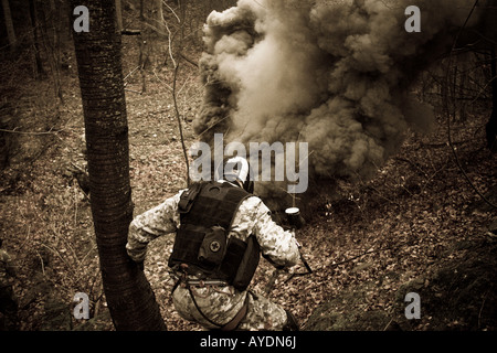 Un soldat anti-terroristes au cours d'une formation. Un gros nuage de fumée noire d'une grenade fumigène dans un peu de distance. Banque D'Images