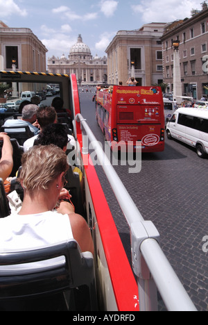 Touristes assis à bord du bus rouge Stop & Go à impériale à toit ouvert près de l'arrêt de la basilique St Peters Square par une chaude journée ensoleillée à Rome Italie Banque D'Images