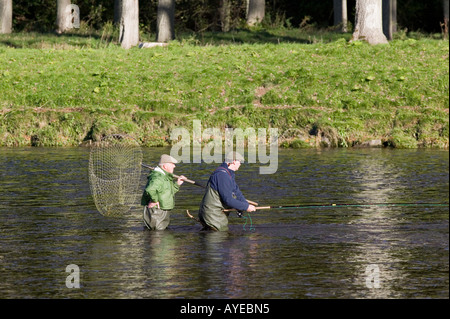 Pêcheur de saumon et ghillie pêcher dans la rivière Tweed, près de St Boswells, Scottish Borders, Scotland Banque D'Images