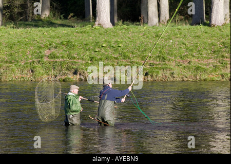 Pêcheur de saumon et ghillie pêcher dans la rivière Tweed, près de St Boswells, Scottish Borders, Scotland Banque D'Images