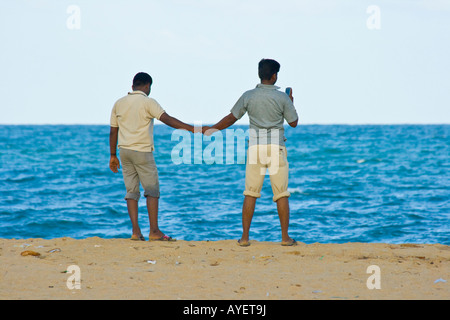 Deux hommes se tenant la main sur la plage de Mamallapuram Inde du Sud Banque D'Images